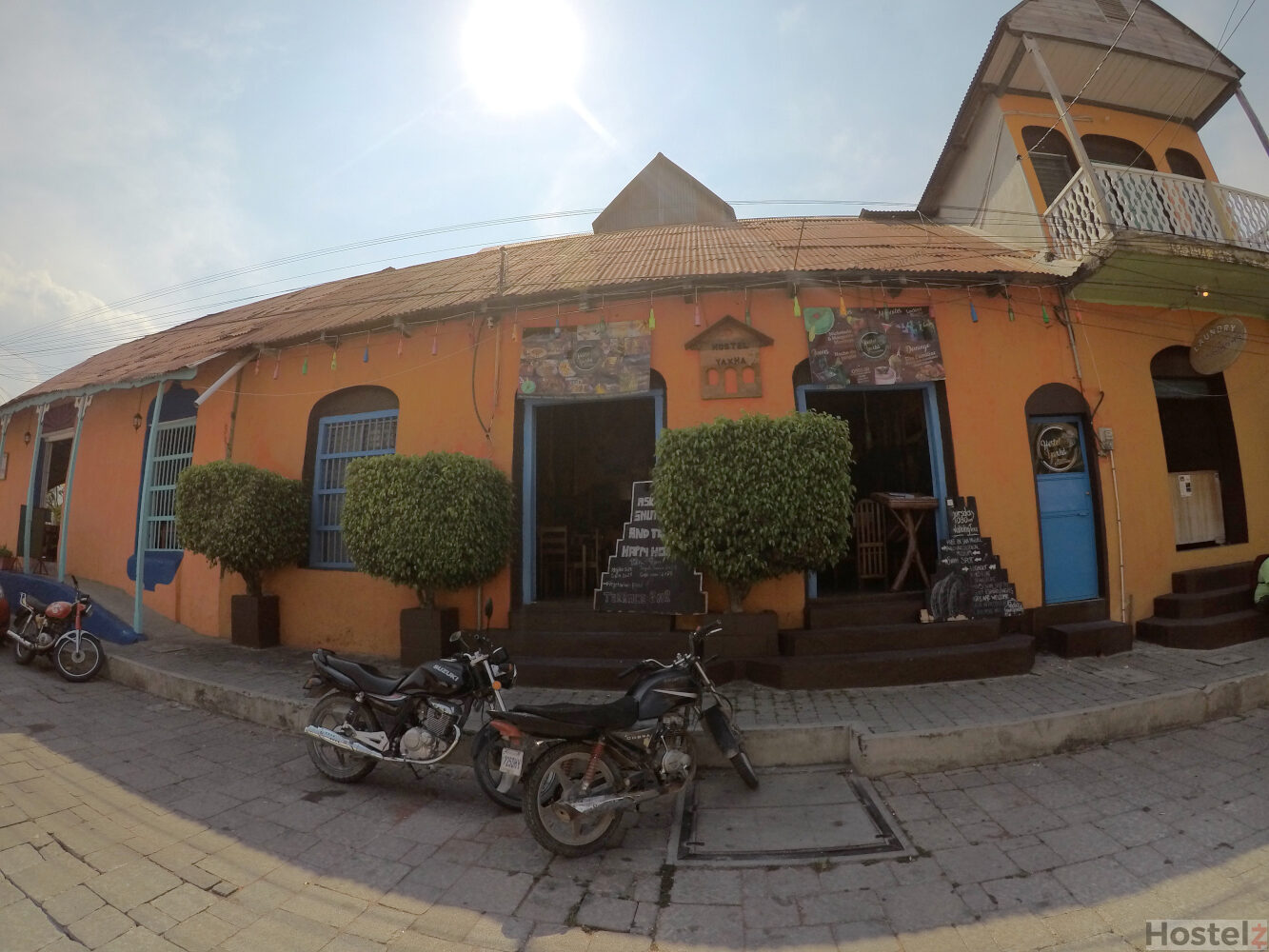 Streetview of the Yaxha Hostel. Bell near small blue door on right.