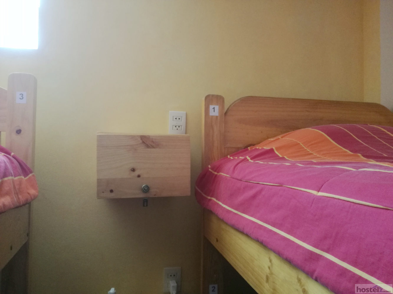 Small locker next to each bed with small hole to charge electronics
