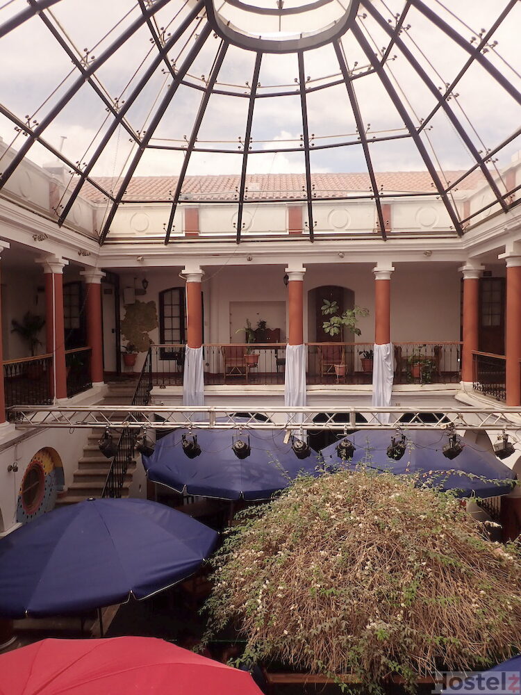 Rooms lead onto a central indoor balcony, with the restaurant occupying the floor below